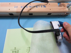 背にアイロンをあてる