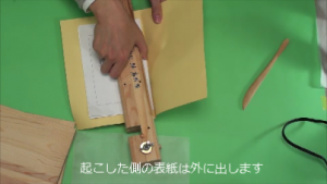 起こした表紙を外に出して製本機で固定します